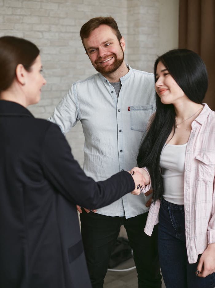 pexels photo 7734593 Three adults shaking hands in a professional meeting setting, showing agreement and positive interaction.